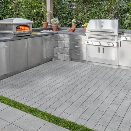Image of outdoor kitchen enhaced with Lunar Path Textured Pavers by Orange Pavers.
